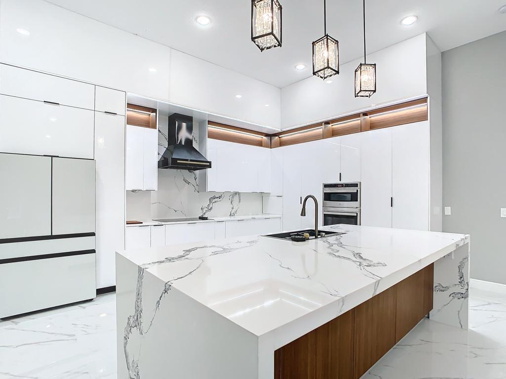 Cocina renovada con isla central y encimeras claras